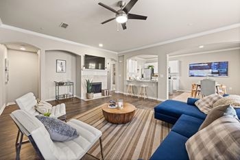A living room with a white chair and a blue couch.